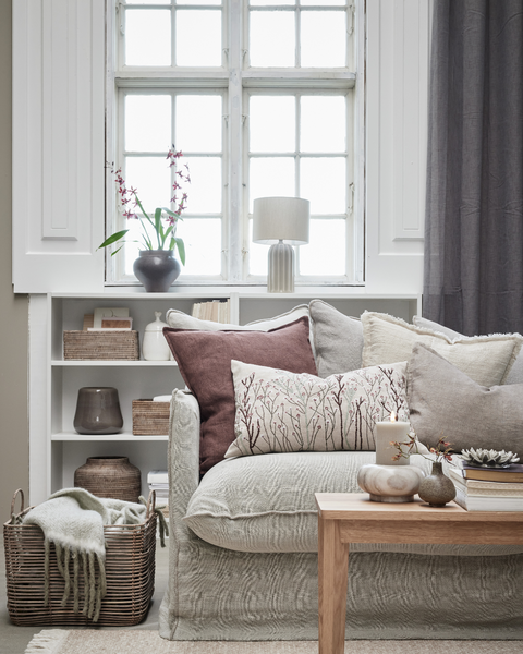 Nordisch eingerichtetes Wohnzimmer mit Herbstfarben, Plaids und Laternen von Lene Bjerre