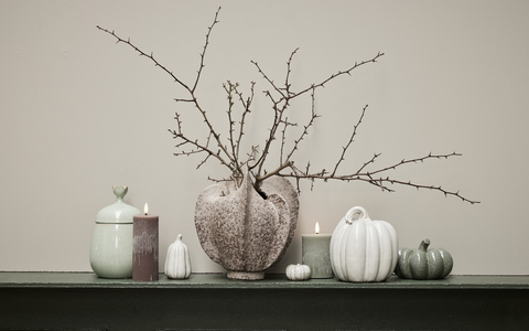 Halloween-Dekoration von Lene Bjerre im eleganten nordischen Stil mit Kürbissen und Kerzen.